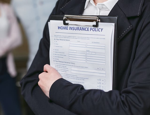 person-holding-clipboard-with-paper-that-says-home-insurance-policy